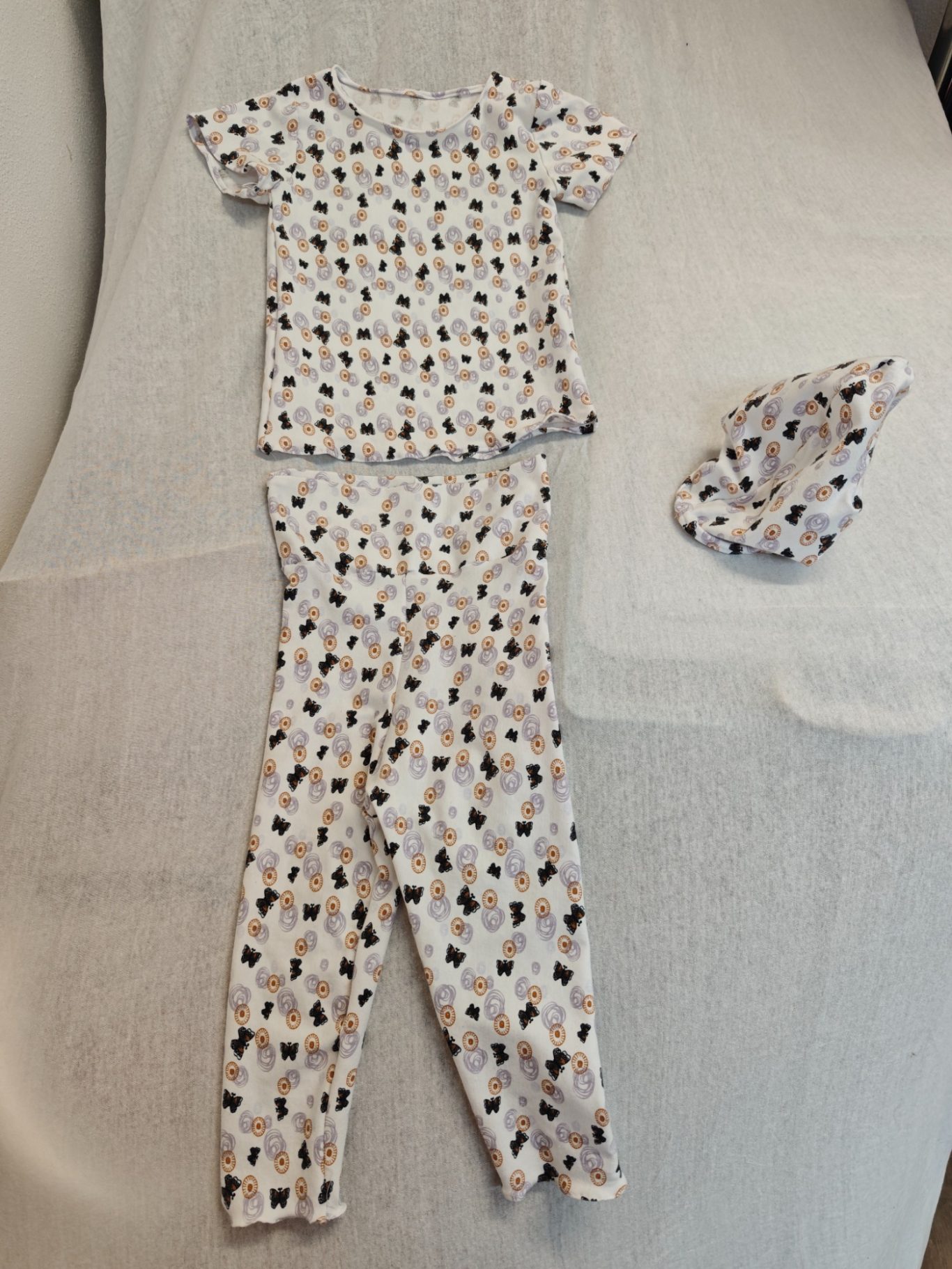 Ensemble - Oberteil und Hose mit Schmetterlingen Über die gesamte Fläche des Schlafanzugs sind bunte Muster und Figuren verteilt.