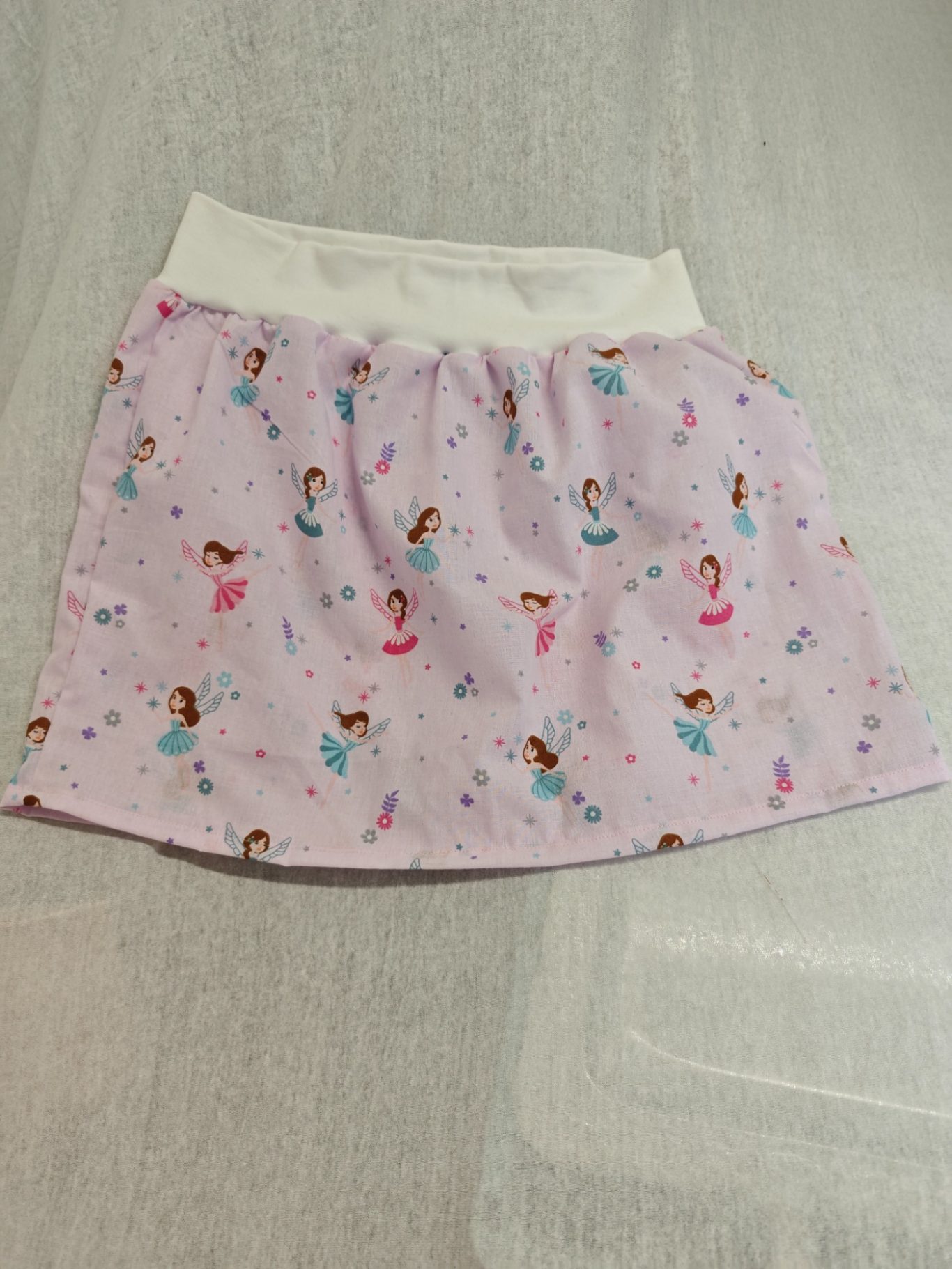 Kinderrock Rosa Kinderrock mit Prinzessinnen- und Sternen-Muster auf weißem Bund.